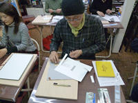 スズキさん。カッターで直線的に紙を切ります。
